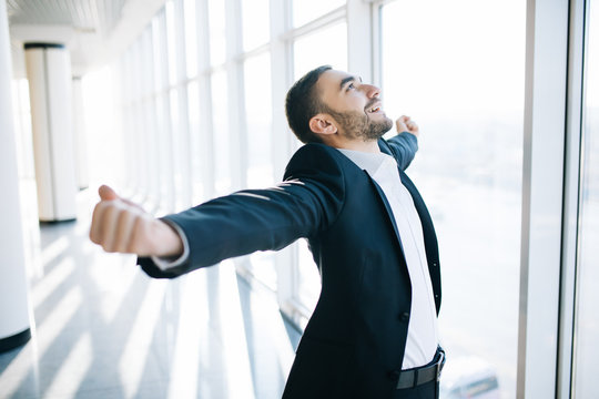 excited young caucasian businessman celebrate victory cheerful in modern office