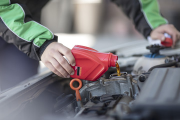 Man filling up car with motor oil