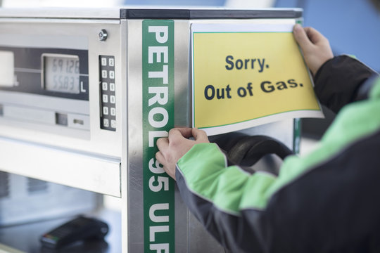 Petrol attendant attaching out of gas sign