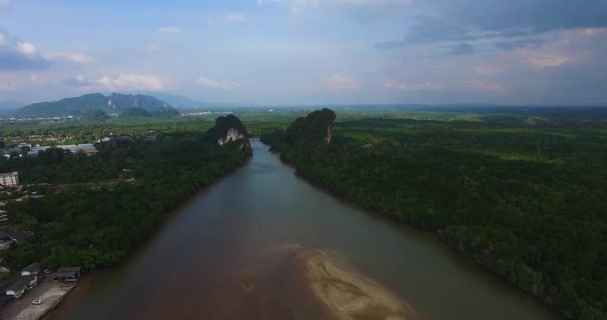 Aerial: The flow of the river between two rocks near traffic road.