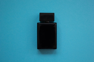 Men's perfume in beautiful black bottle on a blue background.