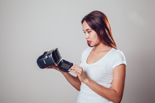 Attractive woman wearing virtual reality goggles on grey background. VR headset.