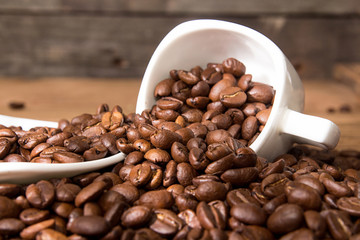 Empty cup and saucer on heap roasted coffee beans.
