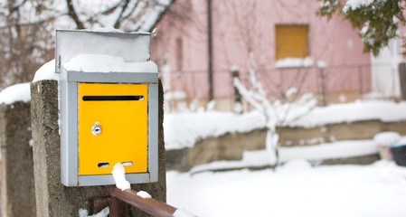 Snow covered mailbox in front of a house