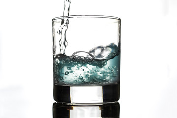 Muddy water in a glass on a white background.