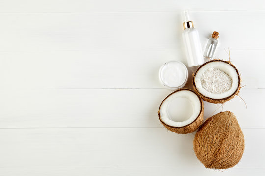 Homemade coconut products on white wooden table background. Oil,