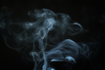 mystery blue smoke over dark background closeup, shallow focus