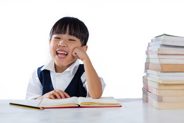 Smiling Asian Chinese little girl wearing school uniform studyin