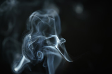 Obraz premium mystery blue smoke over dark background closeup, shallow focus