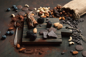 Handmade chocolate with nuts and brambles on a wooden background. Close up