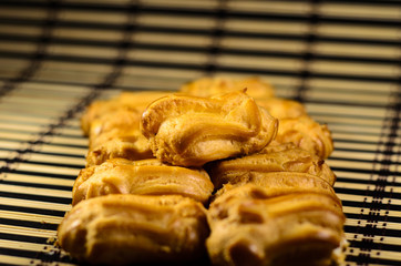 Rows of eclairs on a bamboo mat. Selective focus