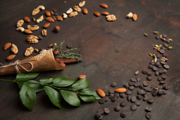 Collection of nuts and chocolate on wooden background. Close up with copy space, selective focus.