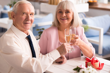 Couple of cute elderly people drinking champagne