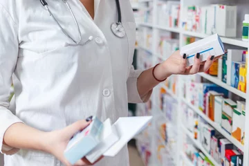 Deurstickers Apotheek Vrouwenapotheker die voorschrift houdt dat geneeskunde in apotheek controleert - drogisterij.