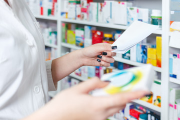 Pharmacien de femme tenant la prescription vérifiant la médecine dans la pharmacie - pharmacie.