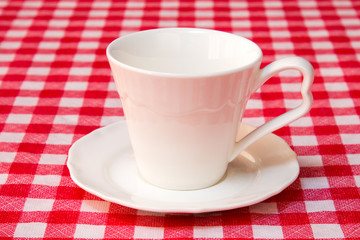White cup on the checkered tablecloth