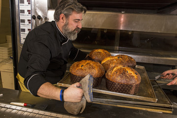 Cocinero y  panetones horneados, horneando panettone.