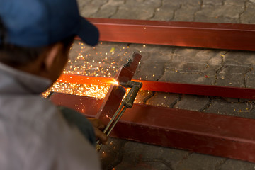 Man using torch cut metal