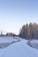 Obraz premium Curvy and snowy road in the country side in Finland. 