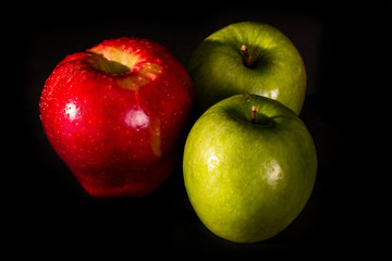 Red and green apples isolated on a black background