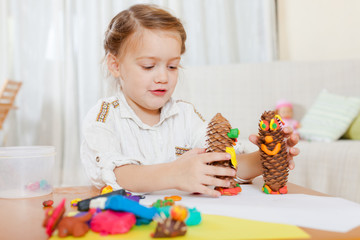 Preschooler molding figurines from plasticine .