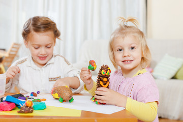  girls playing with plasticine at house