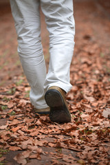 Man walking along the autumn leaves path