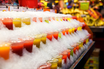 Fruit smoothies are cooled in ice on the market