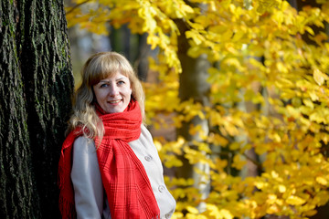 Portrait of the joyful young woman with a red scarf against the