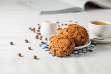 Oatmeal cookies, coffee grains and cup of hot coffee on white table - 132439533