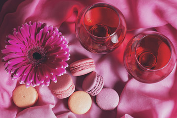 Romantic composition of drinks, sweets and flowers on a pink background