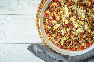 Preparing a pizza on a white table