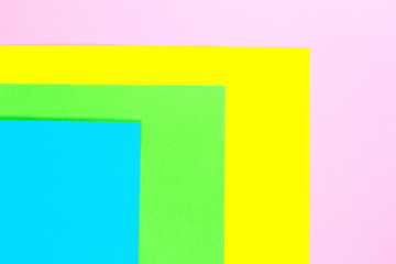 Material design yellow, blue, pink and green paper background. Photo.