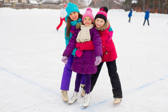 three attractive skater girl hug on the ice