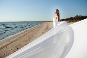 Beautiful bride posing at sea coast