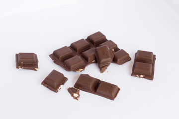  A few cubes of dark chocolate chunks pieces on white background