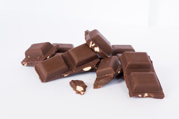  A few cubes of dark chocolate chunks pieces on white background