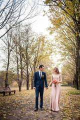 Fototapeta premium Romantic embrace of newlyweds. Couple walks in the park.