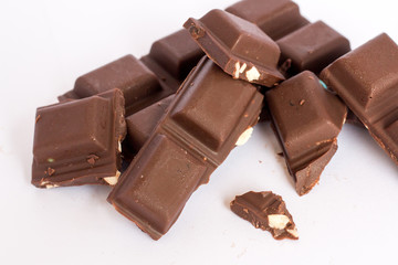  A few cubes of dark chocolate chunks pieces on white background