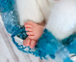 sweet tiny newborn feet on fluffy blanket