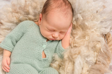 lovely sleeping newborn in overals on fluffy blanket