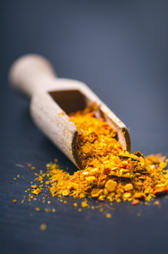 Colorful spices on a dark blue table. Concept of kitchen and cooking. Spicy on a wooden spoon. 