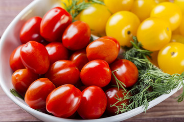 Bunch of red and yellow cherry tomatoes in a bowl