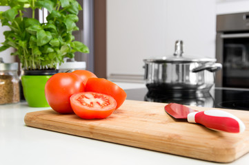 Sliced tomatoes on wooden cutting board in modern kitchen