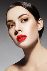 Portrait of young beautiful woman with stylish make-up and glossy red lipstick