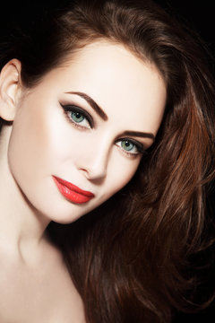 Portrait of young beautiful grren-eyed woman with winged eyes make-up and red lipstick
