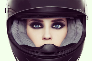 Vintage style close-up portrait of young beautiful woman with stylish make-up in biker helmet