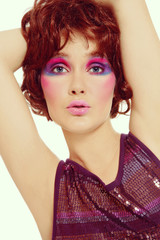 Vintage style portrait of young beautiful dancing girl in sparkly dress and bright crazy disco makeup