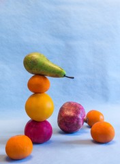 Original fruit balance Fruits of different colors Green pear, pomegranate, apples green and red,orange tangerines, and orange.