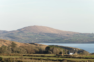 Fototapeta na wymiar A house on the Sheep's Head Peninsula, County Cork, Ireland with Dunmanus Bay and Mizen Peninsula in the background.